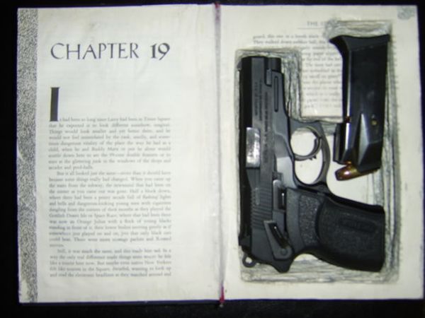 Secret hollow book compartment holding a pistol and magazine