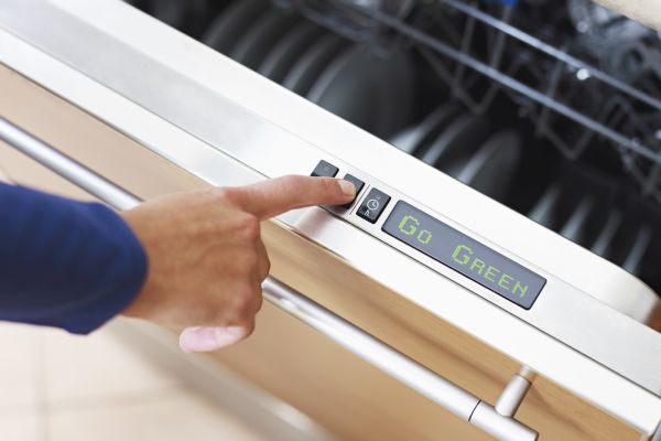 woman pressing energy saver button on dishwasher