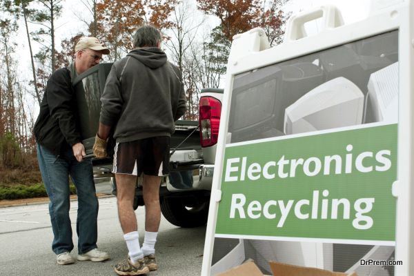 Lawrenceville, GA, USA - November 23, 2013:  Two men carry a discarded television set past an "Electronics Recycling" sign at Gwinnett County's America Recycles Day event.