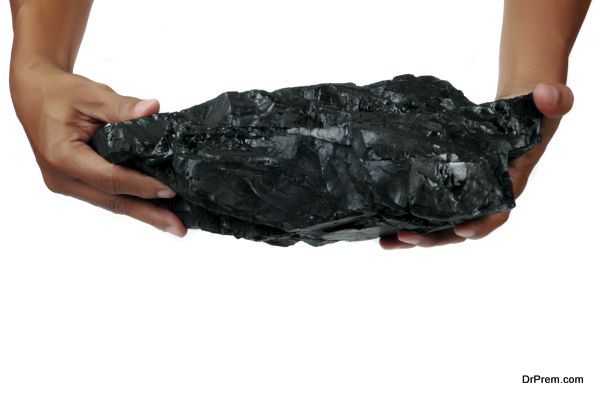 a big lump of coal is held with two hands isolated on white background