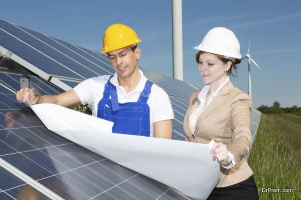 Photovoltaic engineer and contractor with construction plan at solar panels