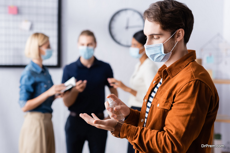 young-employee-using-Sanitizer-at-workplace