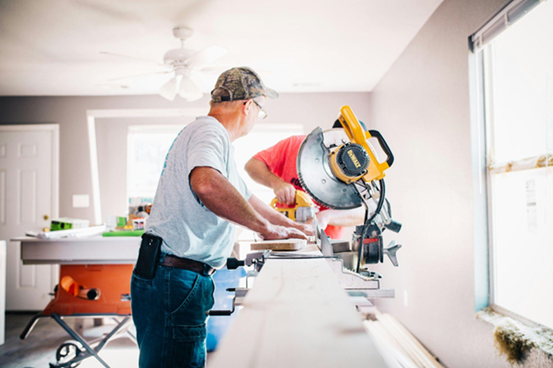 man-standing-infront-of-miter-saw