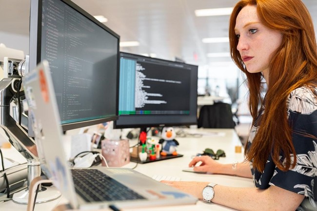 A woman in an office researching professional services automation on her computer